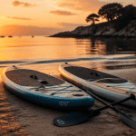 stand up paddle board gonflable et rigide côte à côte sur sable au lever du soleil